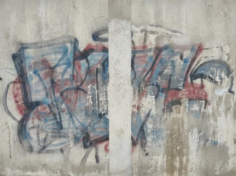 Teilweise entferntes Graffiti: gereinigter Streifen auf der Wand