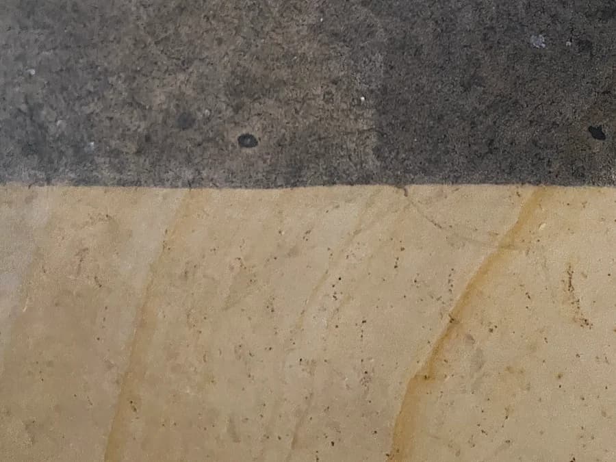 Fassadenfläche mit sichtbarer Kante zwischen behandeltem und unbehandeltem Bereich