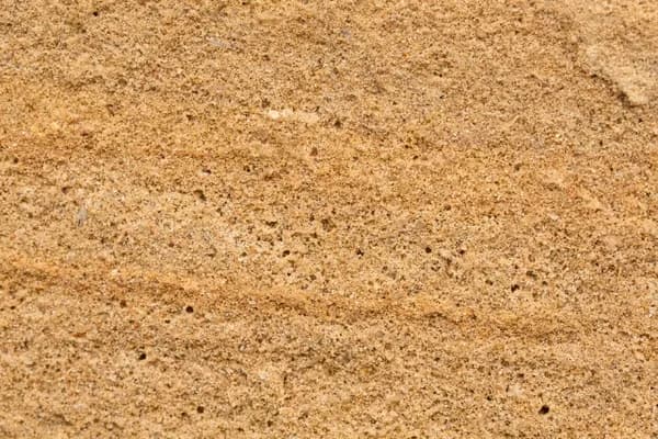 Nahaufnahme einer offenporigen Sandsteinoberfläche