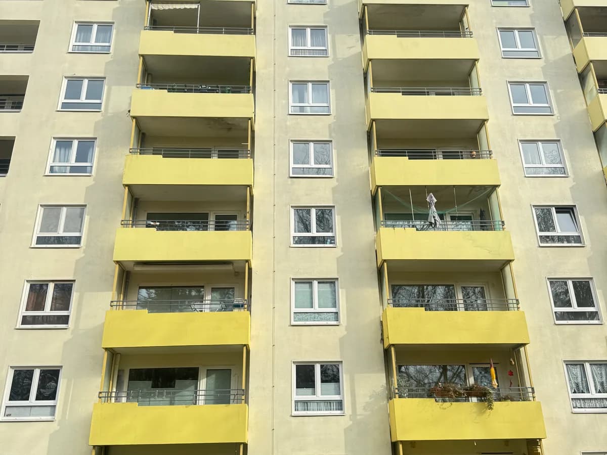 Dieselbe Hochhausfassade nach der Reinigung mit klar gelben Balkonbrüstungen