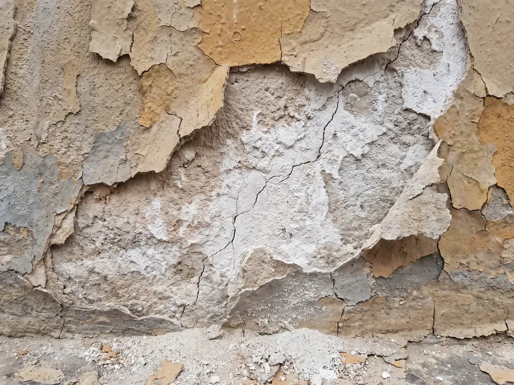 Abplatzende Farbschichten und ein Riss im Außenputz