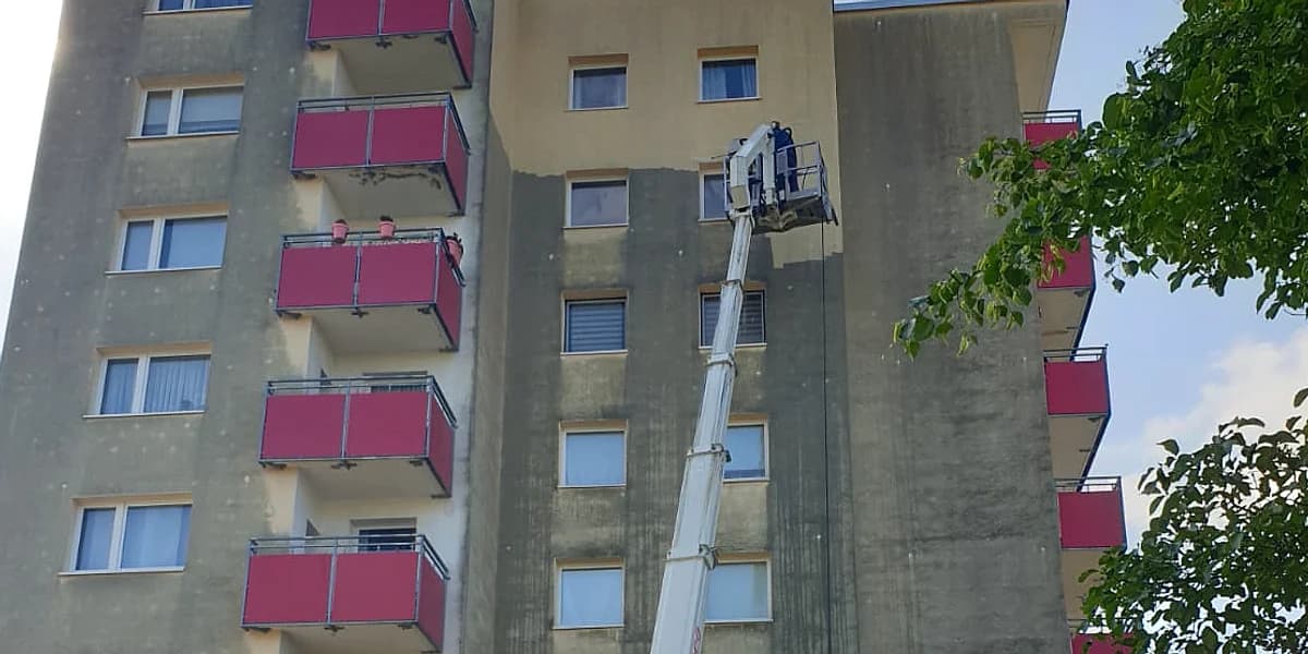 Geschosswohnungsbau mit frisch gereinigter Fassade in Terrakotta und Weiß