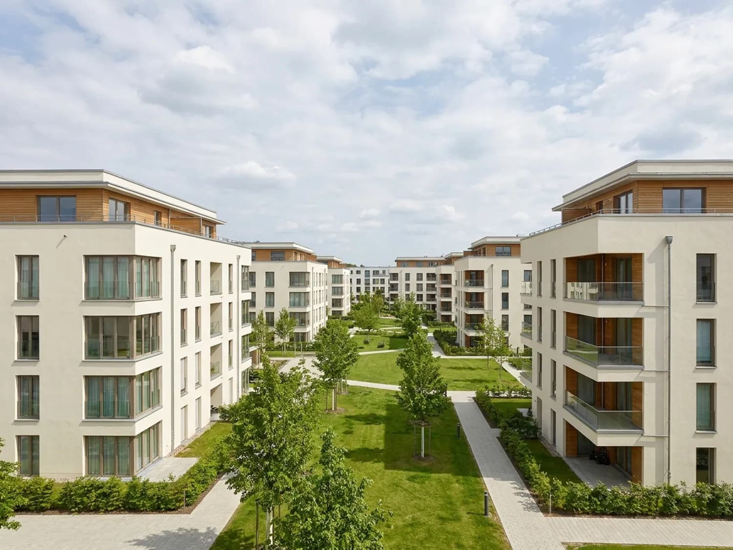 Moderne Wohnanlage mit mehreren Gebäuden um einen begrünten Innenhof