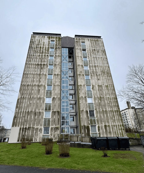 „Stark verschmutzte Hochhausfassade mit Algen- und Schmutzablagerungen vor der Reinigung durch TRODATEC“